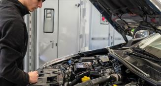 Apprenti inspectant le moteur d'une voiture