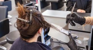 Coiffeuse appliquant une couleur à une cliente